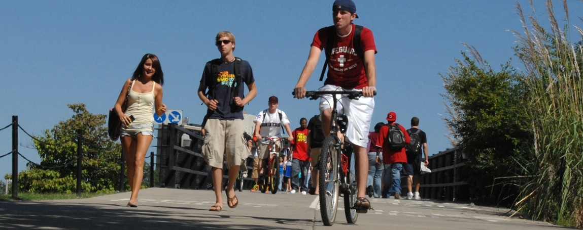 students and bicyclist on bridge